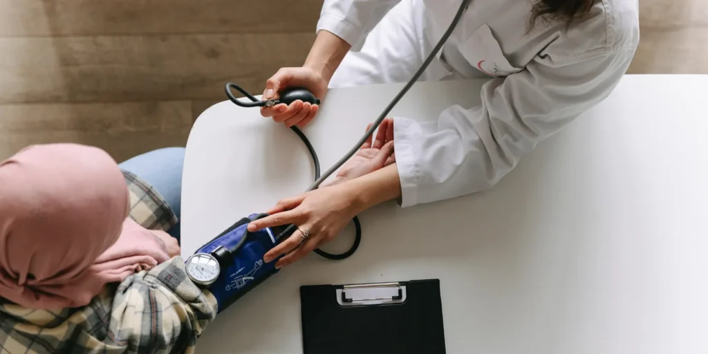 Doctor checking patient's blood pressure.