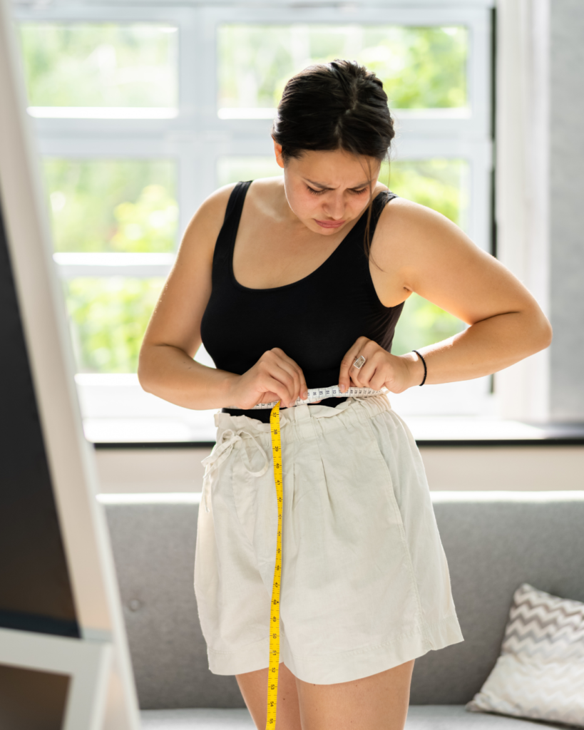 Overweight woman measuring her stomach.